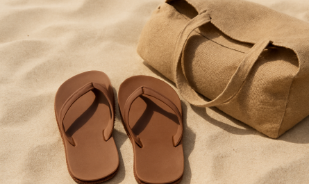 tongs posees sur sable a cote d'un sac