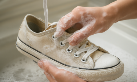 mains lavant délicatement une paire de baskets toile